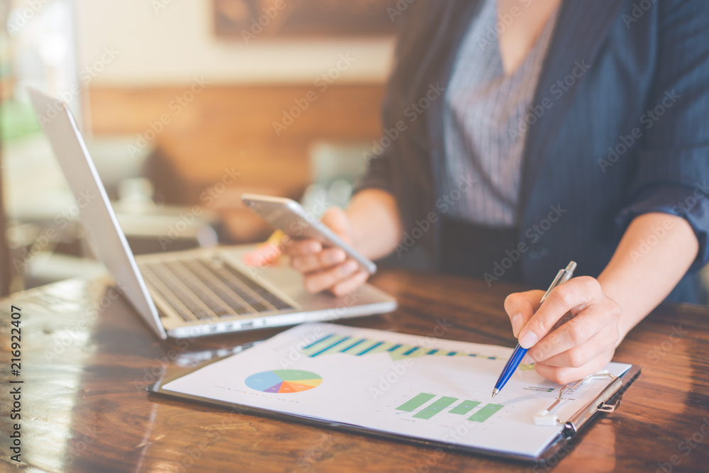 Business woman working on analysis charts and graphs showing results. Business woman working on analysis charts and graphs showing results.