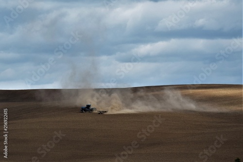 Tractor plowing dusty field 2