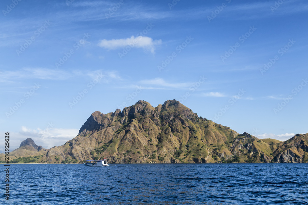 A lone boat next to a cool looking mountain on Pulau Padar island in the Komodo National Park.