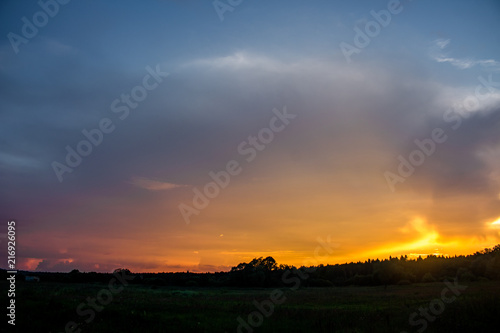 Bright beautiful sunset against a forest background on the horizon © PhotoChur