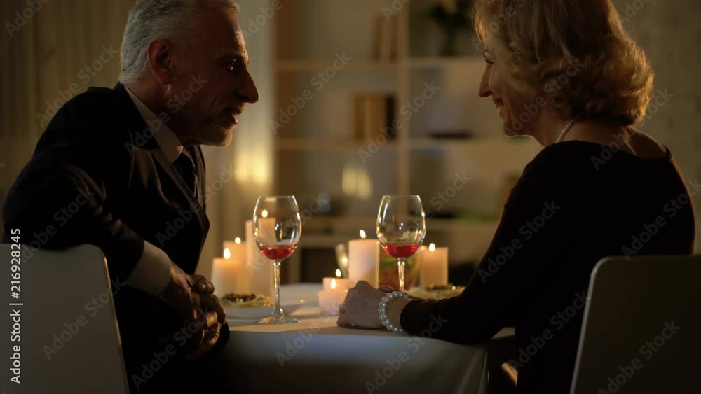 Flirting aged couple drinking wine in luxury restaurant, close friends affection Flirting aged couple drinking wine in luxury restaurant, close friends affection