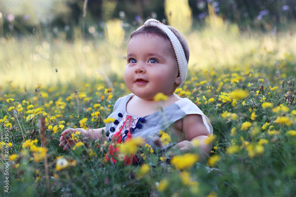 Baby girl sitting on the grass with dandelion flowers on beautiful summer day. Baby girl sitting on the grass with dandelion flowers on beautiful summer day.