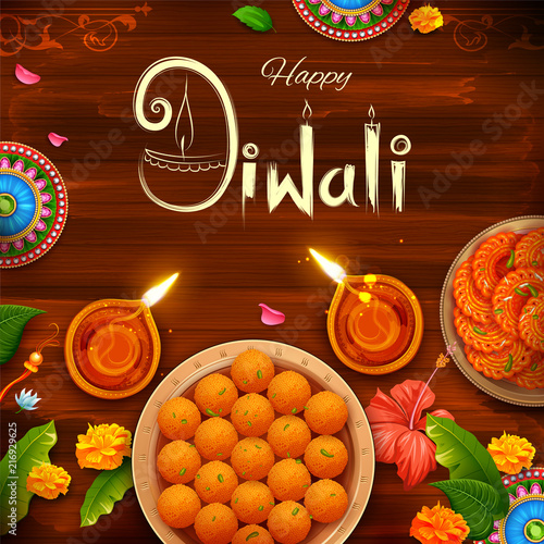 Burning diya with assorted sweet and snack on Happy Diwali Holiday background for light festival of India
