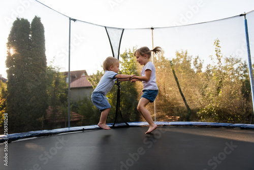 Little kids bouncing off the trampoline taut