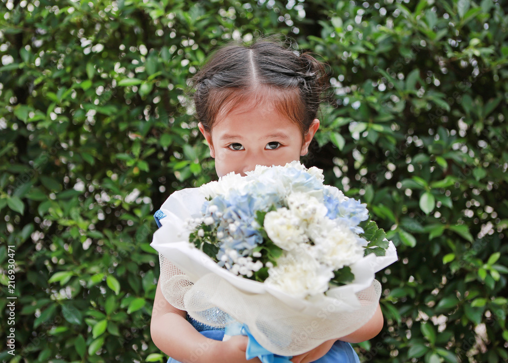 Portrait of cute little child girl smelling Bouquet of flowers in the garden. Portrait of cute little child girl smelling Bouquet of flowers in the garden.