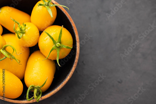 Yellow Tomatoes as high detailed close-up shot on wooden table selective focus. photo