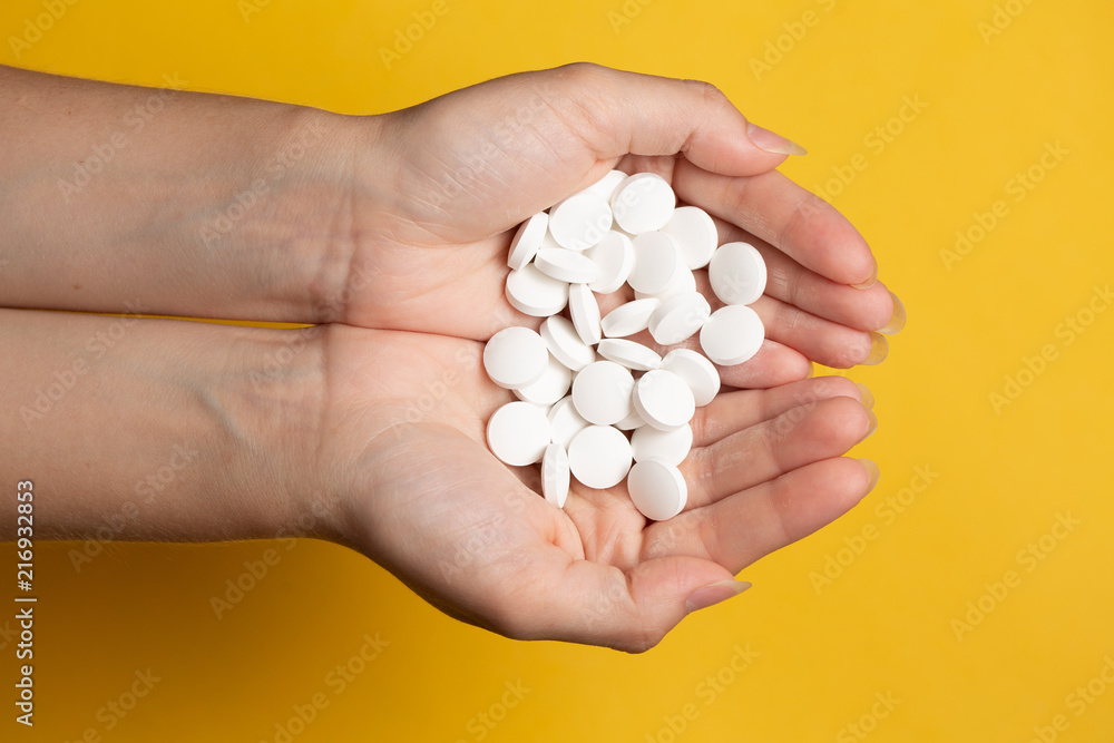 Medicine top view. Pills in hand over yellow table plenty of drugs spread on, Healthcare and medicine concept Medicine top view. Pills in hand over yellow table plenty of drugs spread on, Healthcare and medicine concept