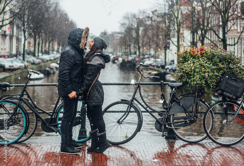 Photography guy and girl in the street in the rain