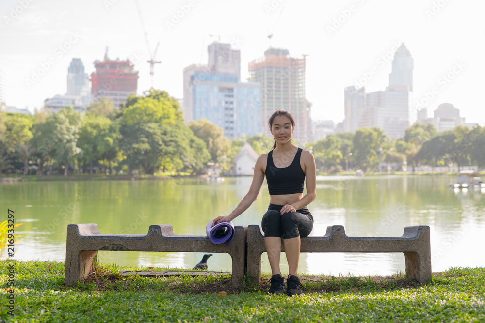 Fototapeta premium Beautiful Asian Woman Sitting In Park Ready For Exercise