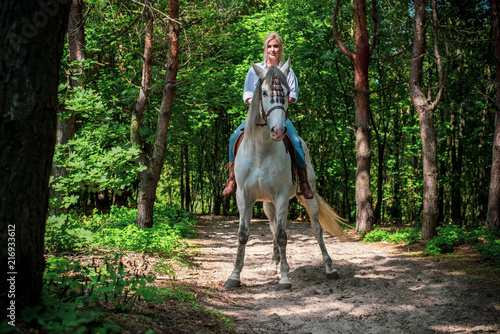 Beautiful american girl with a horse in the nature. Concept of horse and human. Portrait of young artistic woman walking with horse outdoors  © T.Den_Team