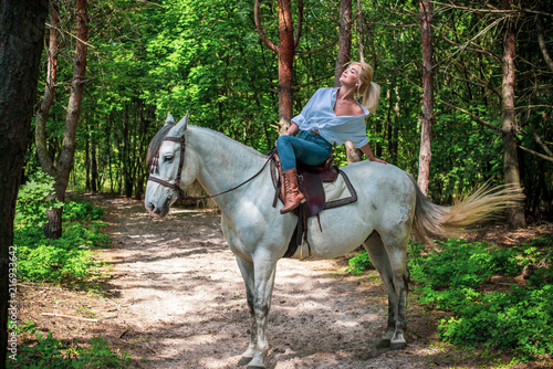 Beautiful american girl with a horse in the nature. Concept of horse and human. Portrait of young artistic woman walking with horse outdoors  © T.Den_Team