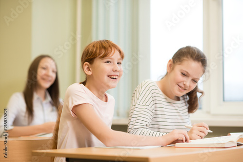 3 student girls are sitting at a Desk