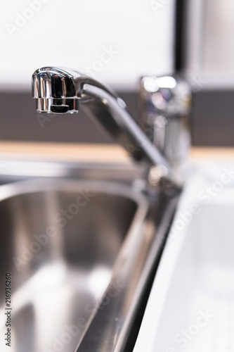 A stainess steel tap on blurred background.