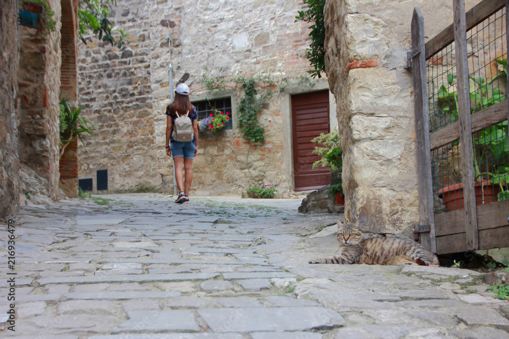 Backpacker girl walking in Montefioralle, one of the most beautiful villages in Italy. Tuscany.