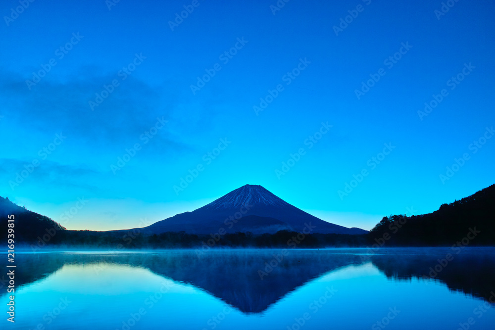 夜明け前の毛嵐が立ち込める精進湖と富士山

