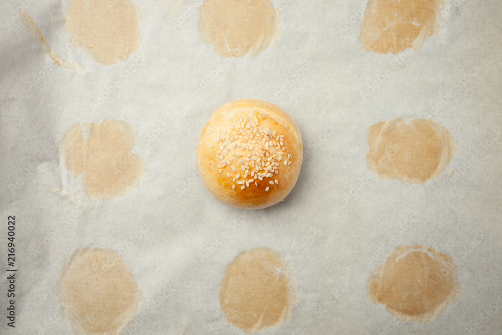 Homemade burger bun on bakery parchment . Food photography, concept of homemade fresh bakery. Rolls with sesame seeds hamburger with sesame, pumpkin, flax, sunflower seeds Homemade burger bun on bakery parchment . Food photography, concept of homemade fresh bakery. Rolls with sesame seeds hamburger with sesame, pumpkin, flax, sunflower seeds