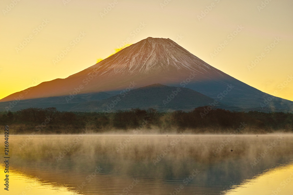 朝焼けと毛嵐が立ち上る精進湖と富士山


