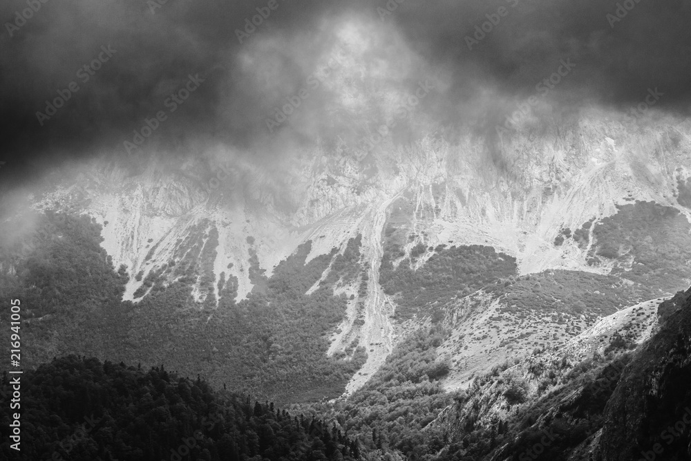 Obraz premium Mountain cliff during storm. Black and white image.