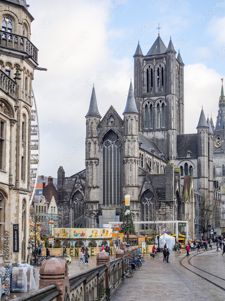 Fototapeta premium GHENT, BELGIUM - December, 2017: View of the ancient bridge of Saint Michael, old post office and church of St. Nicholas in the historical center of Ghent, Belgium