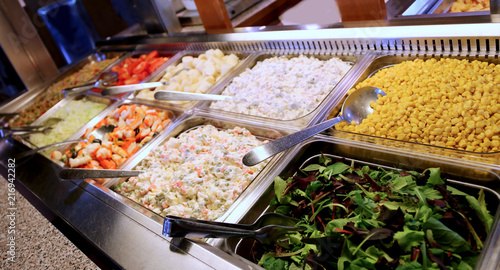 Fotografie self service restaurant with many trays filled with lettuce corn