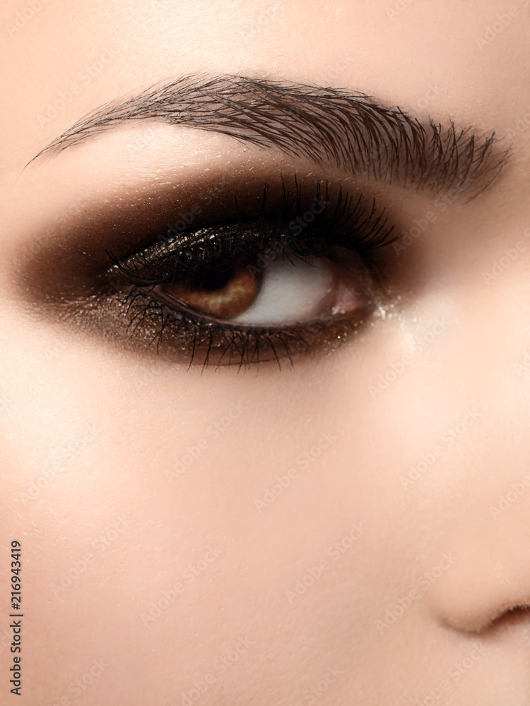 Obraz premium Beautiful macro shot of female eye with extreme long eyelashes and black liner makeup. Perfect shape make-up and long lashes. Cosmetics and make-up. Closeup macro shot of fashion eyes maquillage