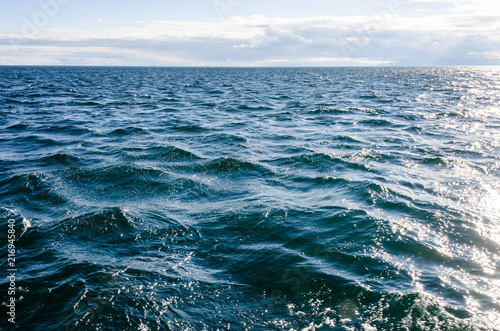 Waves on surface of water with cloudy sky