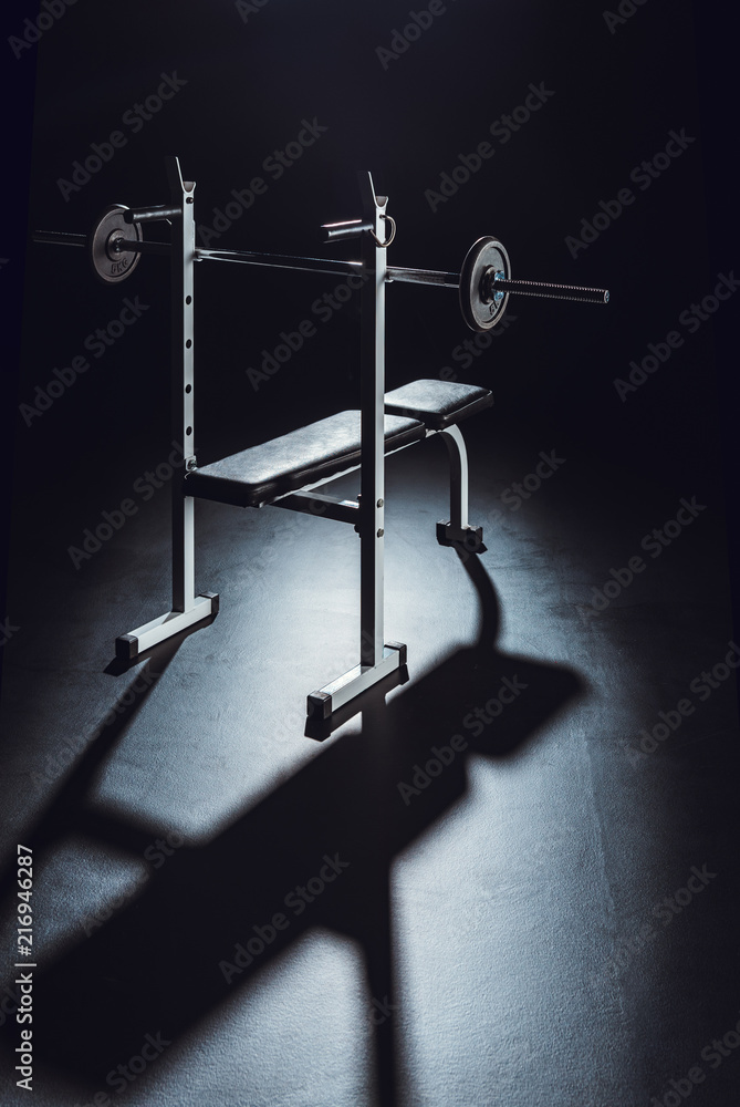 barbell with shadow on floor at gym, black background