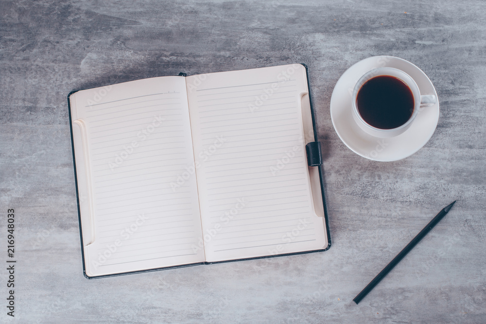 Business or planning concept: Top view image of open notebook with blank pages and coffee cup on grey table background, mock up Business or planning concept: Top view image of open notebook with blank pages and coffee cup on grey table background, mock up