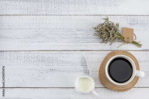 A cup of coffee and milk with caspia bouquet on white wood background with copy space