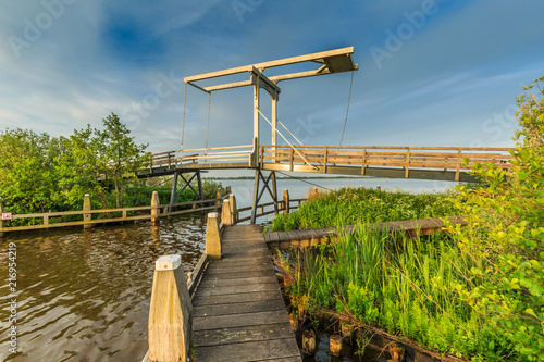 Drawbridge in paved cycle path from Meije to Nieuwkoop right through the Nieuwkoopse plassen about a centuries-old road caused by dredging peat for fuel with a sky full of insects