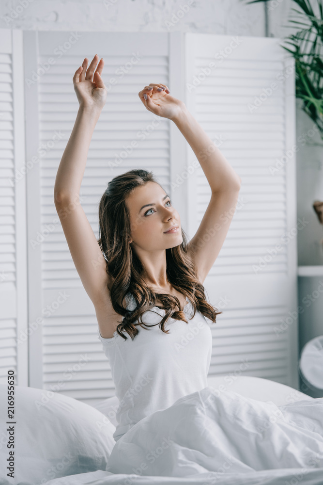 beautiful young woman sitting on bed and stretching hands beautiful young woman sitting on bed and stretching hands