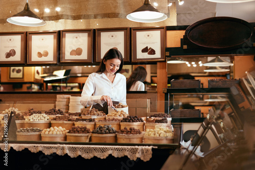Fotografija Confectionery. Woman Selling Chocolate Candies In Store
