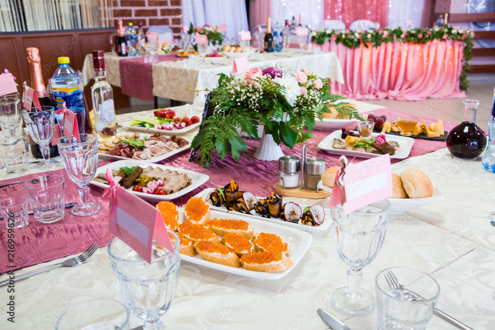 Served tables at the Banquet. Drinks, snacks, delicacies and flowers in the restaurant. A gala event or wedding.