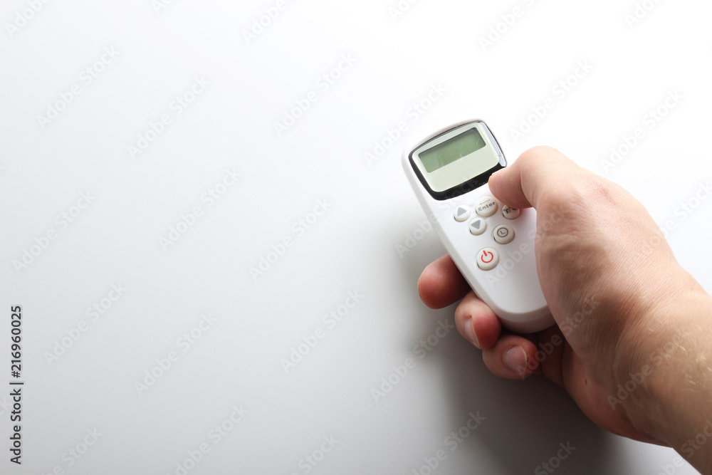 white remote with buttons in hand white remote with buttons in hand
