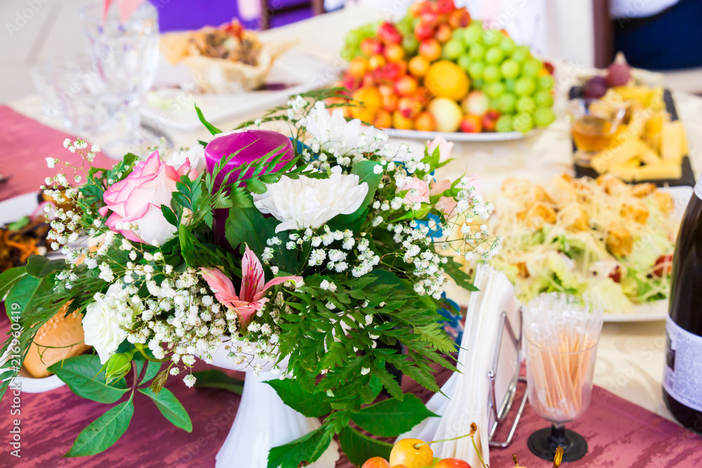 Served table at the Banquet. Fruits, snacks, delicacies and flowers in the restaurant. Solemn event or wedding. Served table at the Banquet. Fruits, snacks, delicacies and flowers in the restaurant. Solemn event or wedding.