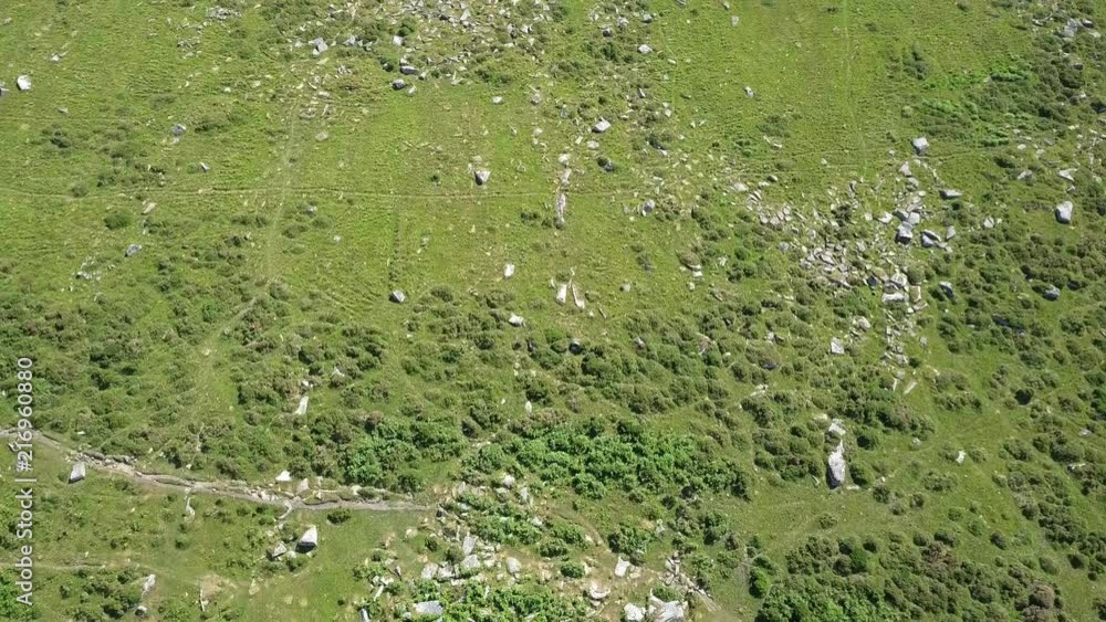 Wide aerial birdseye shot of a rocky area surrounded by forest, green bracken and grassy moorland, Dartmoor, England, Wistmans wood Wide aerial birdseye shot of a rocky area surrounded by forest, green bracken and grassy moorland, Dartmoor, England, Wistmans wood