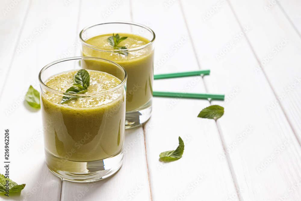 Refreshing green smoothie on the white table Refreshing green smoothie on the white table
