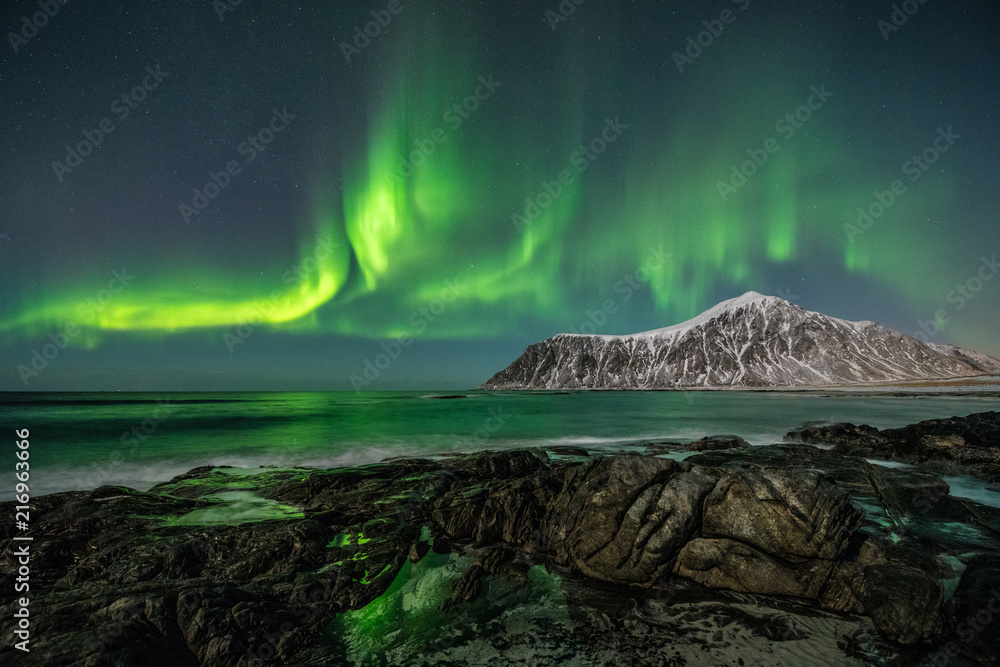 Norway - Lofoten island -  Skagsanden beach rocks with large Aurora
