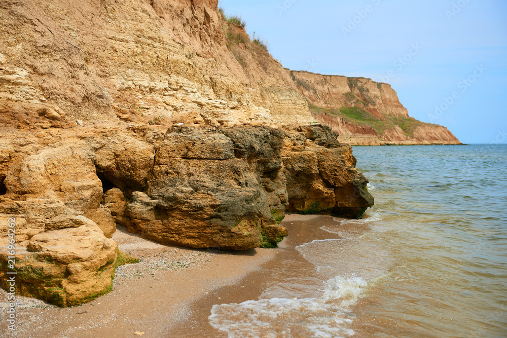 beautiful sea landscape, closeup of stone on the beach, sea coast with high hills, wild nature