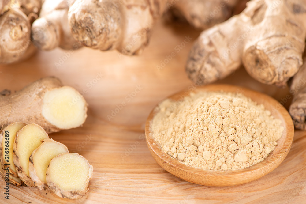Ginger root, ginger slice and ginger powder on wooden background table, space for text. Ginger root, ginger slice and ginger powder on wooden background table, space for text.