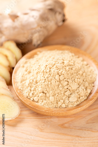 Ginger root, ginger slice and ginger powder on wooden background table, space for text.