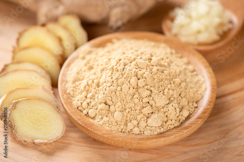 Ginger root, ginger slice and ginger powder on wooden background table, space for text.