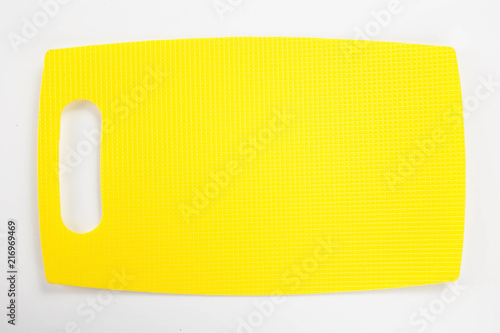Yellow plastic kitchen cutting board isolated on white background