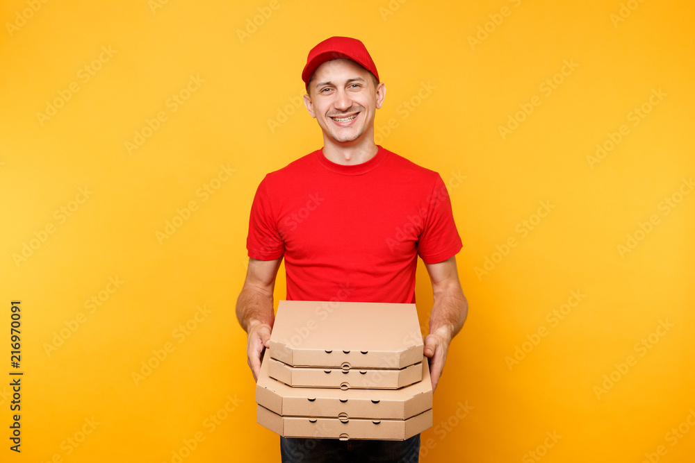 Delivery man in red cap, t-shirt giving food order pizza boxes isolated on yellow background. Male employee pizzaman or courier in uniform holding italian pizza in cardboard flatbox. Service concept. Delivery man in red cap, t-shirt giving food order pizza boxes isolated on yellow background. Male employee pizzaman or courier in uniform holding italian pizza in cardboard flatbox. Service concept.