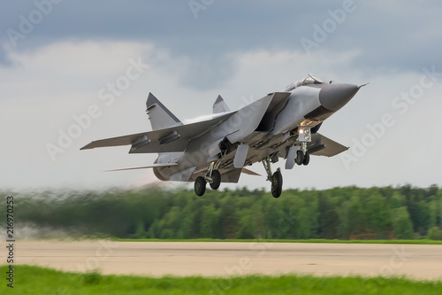 Air military bomber perfoming take off from the airbase runway in Russia. Air fighter flying around base. Aviation mission of military flight. photo