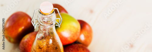 Bottle of fresh apple cider and near autumn apples