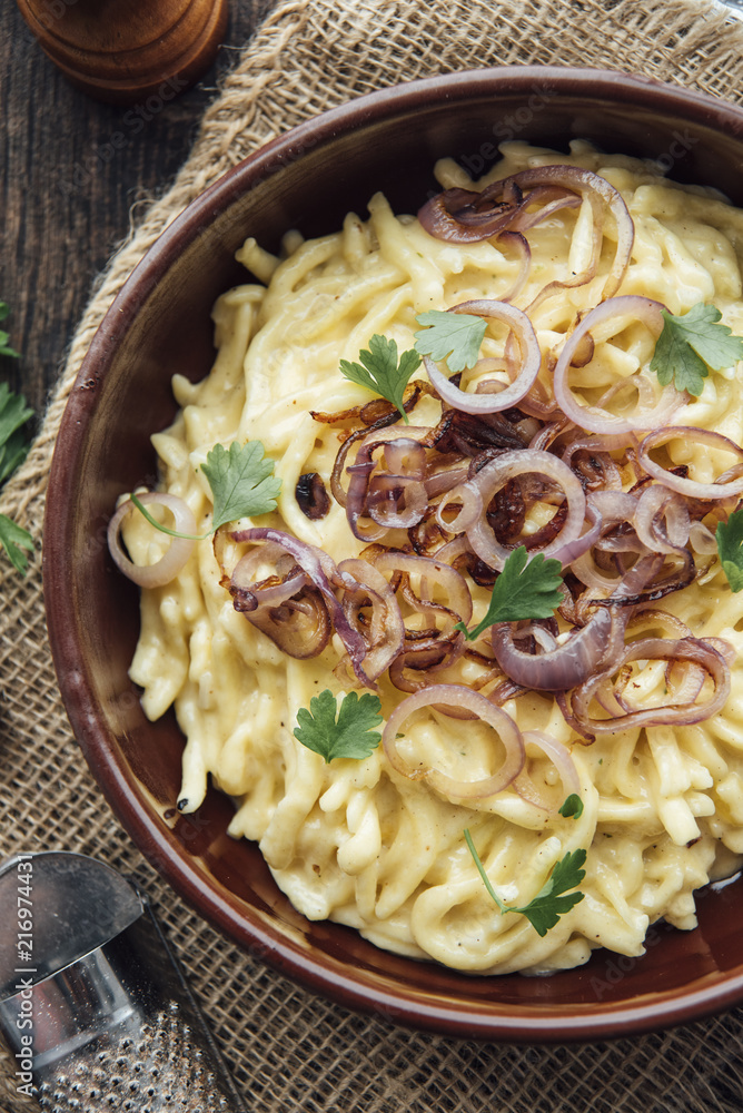 Traditional Swabian cheese spaetzle, egg noodles with cheese, cream,  roasted onions foto de Stock | Adobe Stock