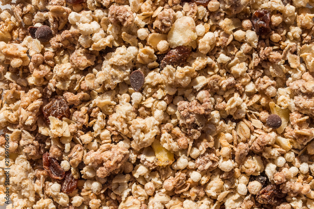 Muesli breakfast with oatmeal cereals raisins. Close up view of crunchy granola, muesli pile with banana slices and chocolate. Can be used as a background. Top view. Healthy eating. proper nutrition. Muesli breakfast with oatmeal cereals raisins. Close up view of crunchy granola, muesli pile with banana slices and chocolate. Can be used as a background. Top view. Healthy eating. proper nutrition.