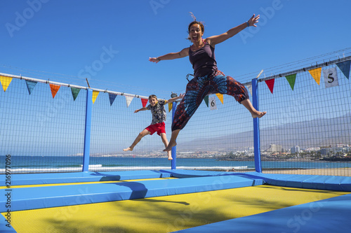 mother and young child son caucasian playing and jumping like crazy having a lot of fun in vacation. outdoor leisure activity for beautiful family and people