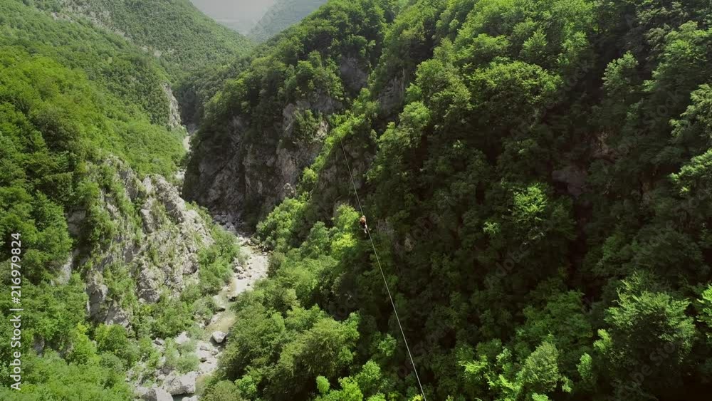 Aerial view of couple canopying over the forest in zip-line at Slovenia. Aerial view of couple canopying over the forest in zip-line at Slovenia.